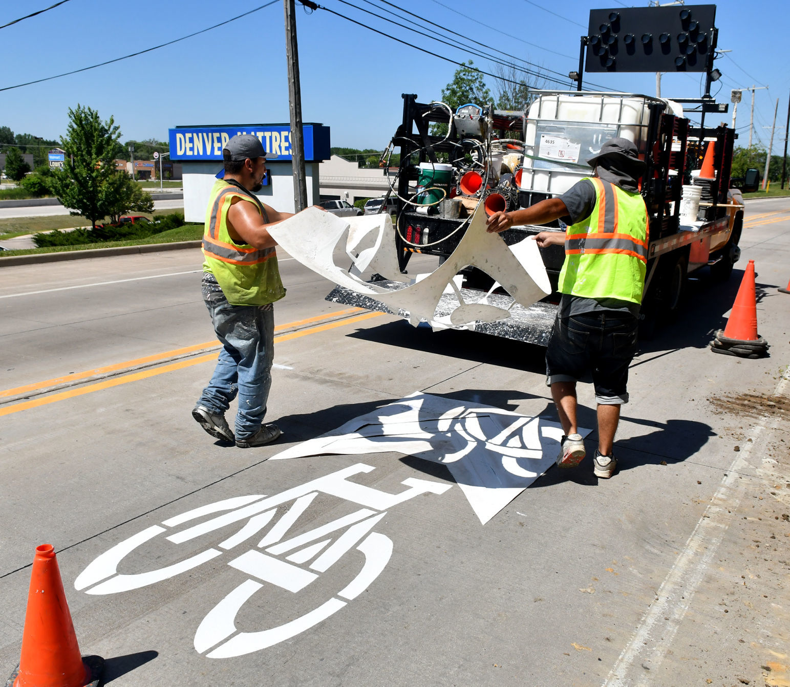 Painting of sharrows for bike lanes in Moline.